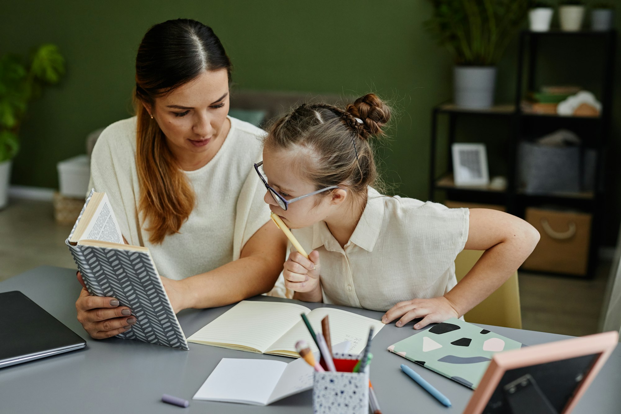 Mother Helping Girl with Down Syndrome Studying at Home
